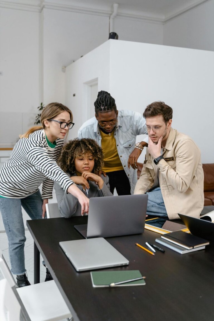 Four people looking at a laptop together